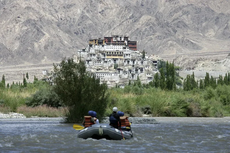 Rafting na rzece Indus, w tle klasztor Thikse (Thiksey) koło Leh