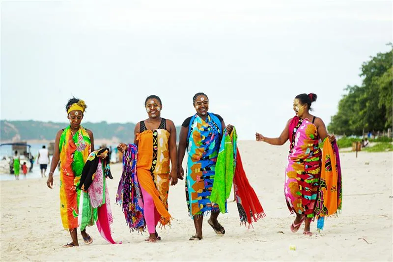 Kobiety sprzedające turystom kolorowe chusty na madagaskarskiej plaży © ONTM