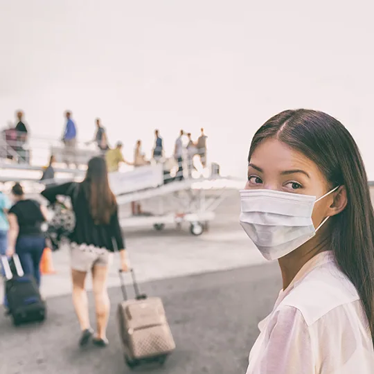 Girl wearing a mask and getting onto a plane
