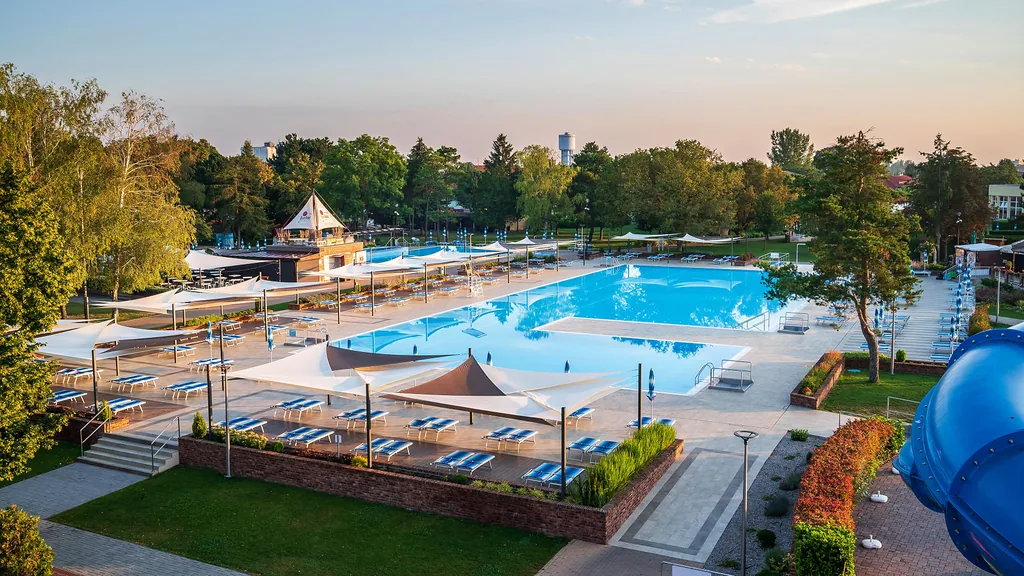 Zewnętrzne baseny i strefa wypoczynkowa z leżakami w komfortowym ośrodku Thermalpark Dunajská Streda