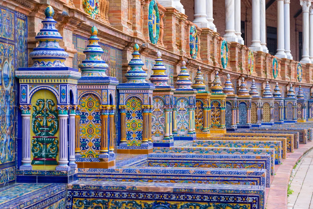Wyłożone kolorowymi płytkami ceramicznymi ławki na placu Hiszpańskim (Plaza de España) w Sewilli
