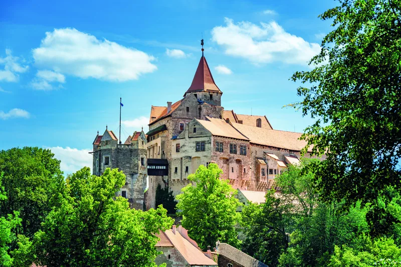 Pernstejn, Czech Republic - 7.8.2022: Outdoor view of Pernstejn castle near the Nedvedice village, Czech Republic. Fairytale castle on hill during summer day. B