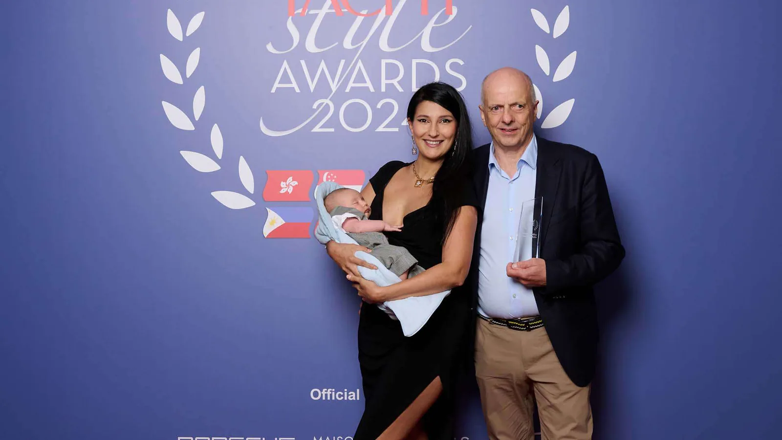 Rodzina pozująca do zdjęcia na wydarzeniu Yacht Style Awards 2022, z logotypami firm takich jak Sunreef Yachts i Porsche w tle.