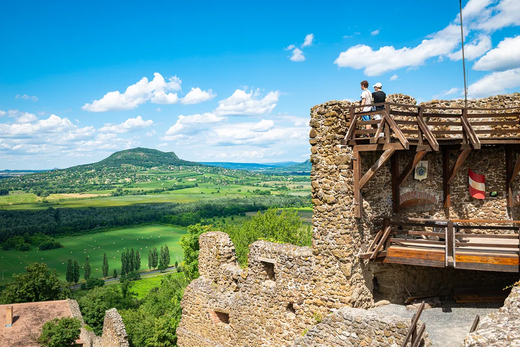 Szigliget, Hungary - July 2022: Ancient tower of Szigliget castle with hilly hungarian countryside in the background.