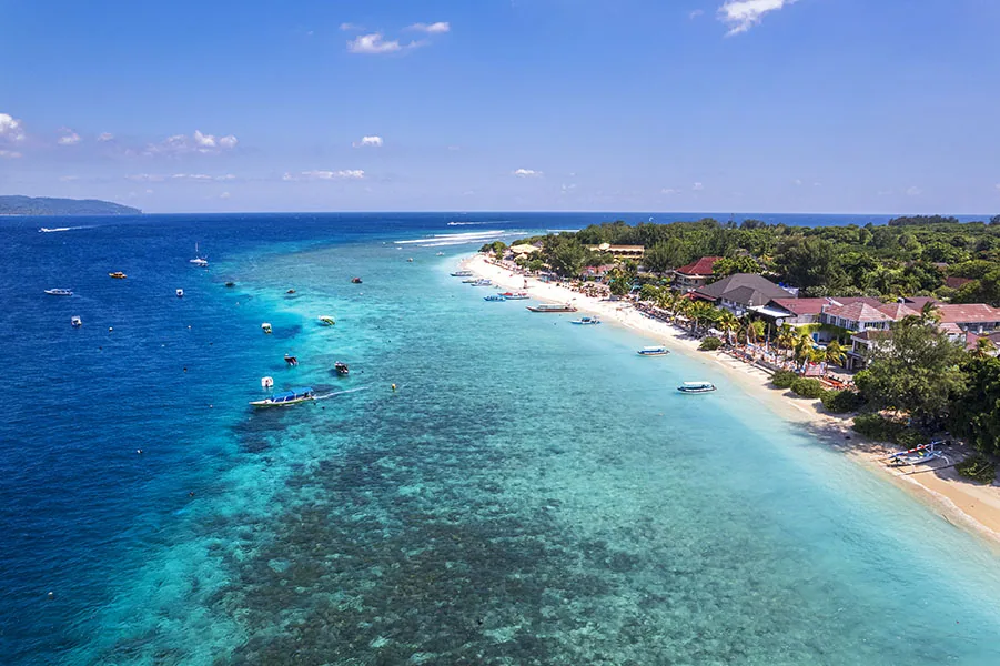 Aerial view of the tropical island of Gili Trawangan with crystal water and anchored boats, Gili Islands, Lombok, East Nusa Tenggara, Indonesia