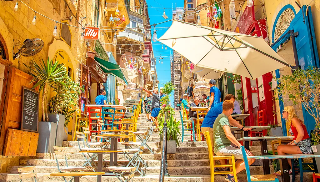 Valletta, Malta - 2 May, 2024: Street summer cafe in Valletta old town. People sitting in a cafe.