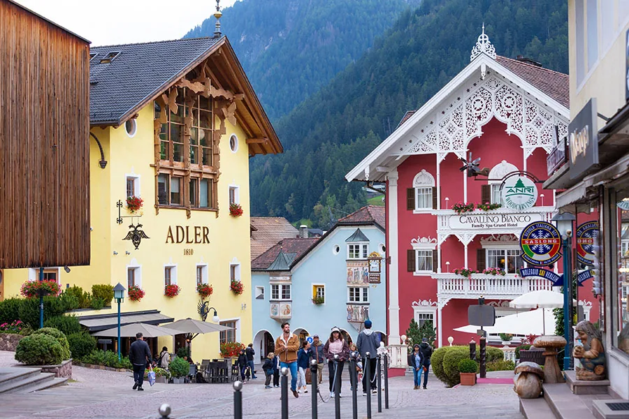 Ortisei, Italy- September 26, 2024: Summer street view in alpine village in Dolomites with people and colorful houses