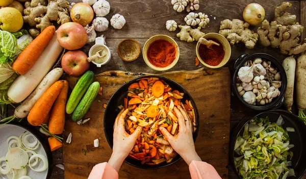 Hand holding knife and slice kimchi cabbage on wooden cutting board for cooking, Korean food