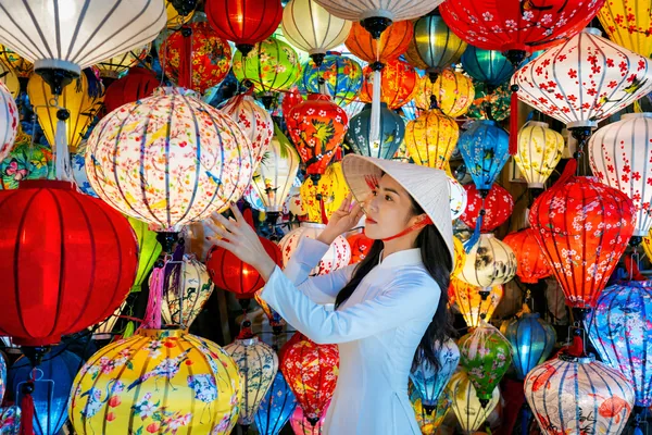 Asian woman wearing vietnam culture traditional and hoi an lanterns at Hoi An ancient town, Vietnam.