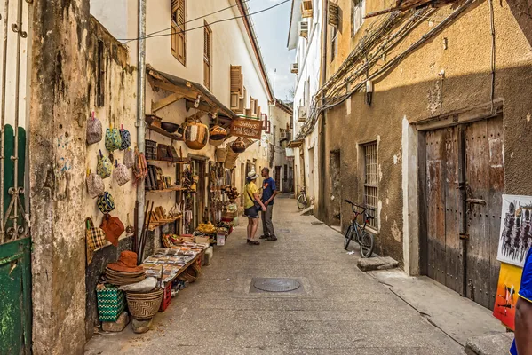 Stone Town, Zanzibar - October 24, 2014 : Tourists on a typical narrow street in Stone Town. Stone Town is the old part of Zanzibar City, the capital of Zanziba